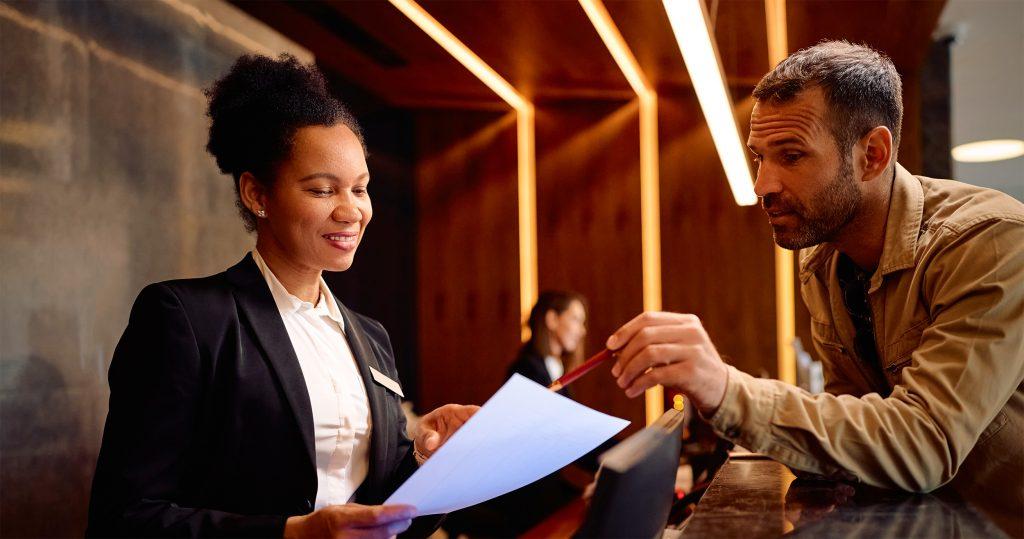 Hotelmitarbeiterin im Gespräch mit einem Gast im Hotelbereich